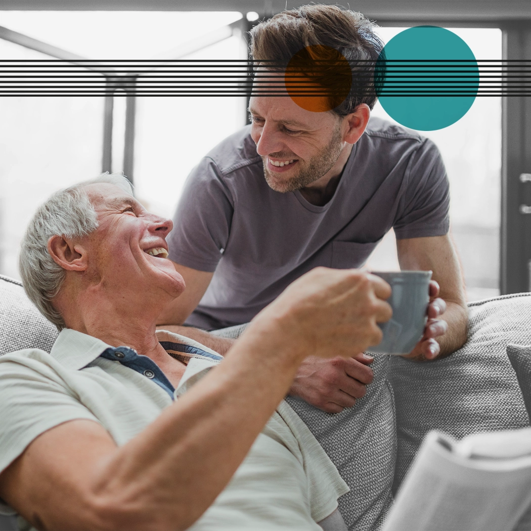 Elderly man laughing with younger man